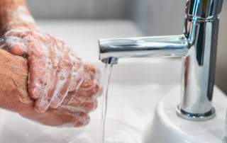 Man washing hands to prevent COVID-19 virus spread.